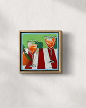 Load image into Gallery viewer, Two Aperol spritz on red and white
